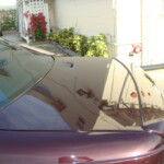 Before and after photographs of a damaged Chevy Impala that was repaired by Elite Paint & Body Shop in West Palm Beach, Florida.